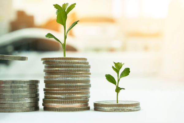 Stacked coins with small green plants sprouting from them